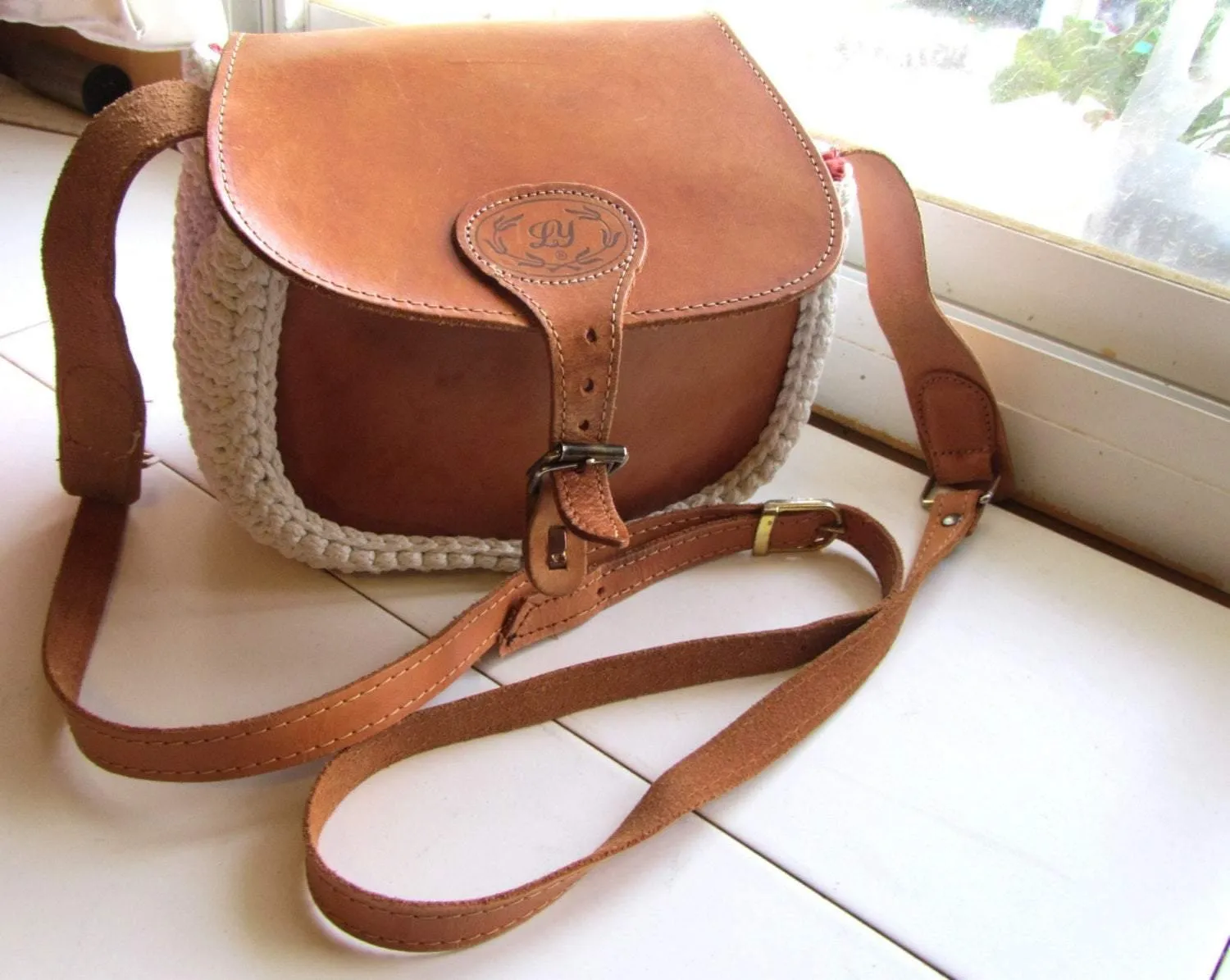 Crossbody / Shoulder bag made out of thick leather with a knitted fragment on a long leather strap